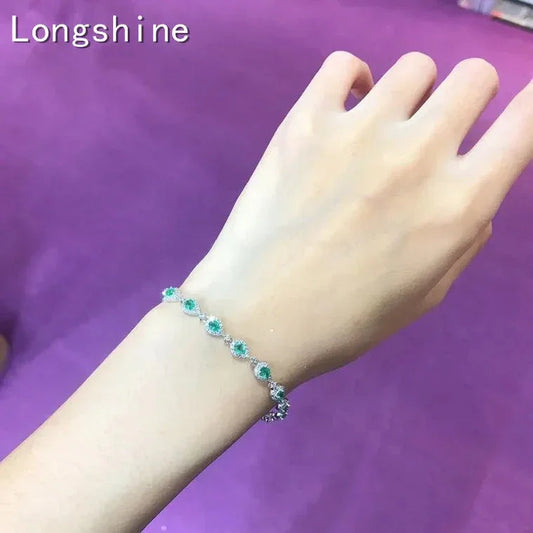Elegant 18K gold emerald diamond bracelet worn on wrist with green gemstones and sparkling diamonds